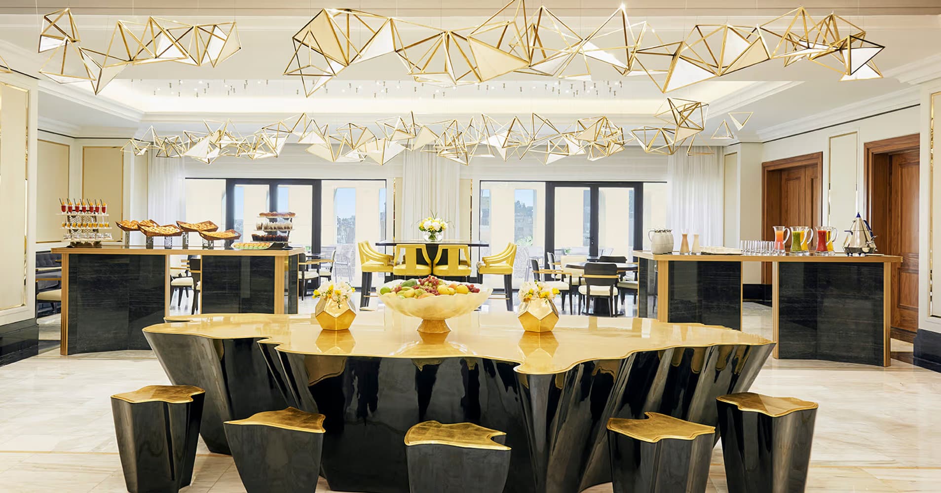 Geometric gold chandeliers illuminating a modern event space at the Fairmont Amman